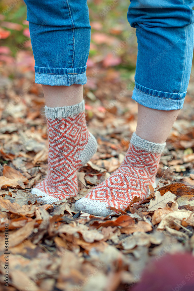 Handmade knitted socks on the background of leaves Handmade knitted socks on the background of leaves
