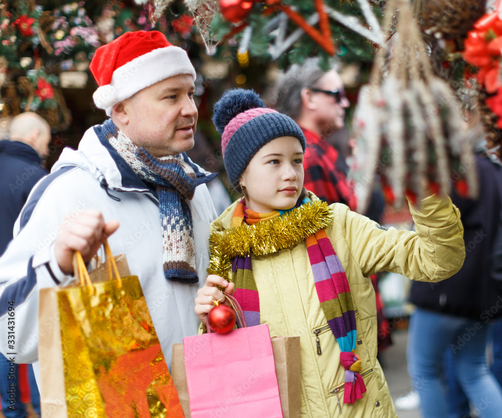Girl with father choosing Xmas decoration