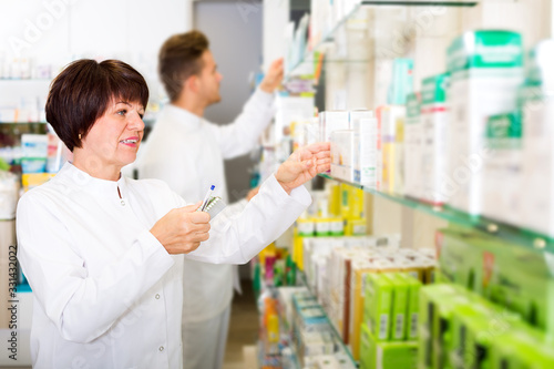 Pharmacist and pharmacy technician posing in drugstore