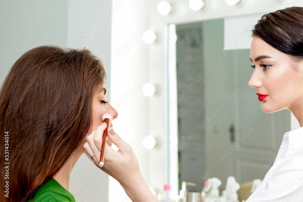 Make-up artist applying powder.