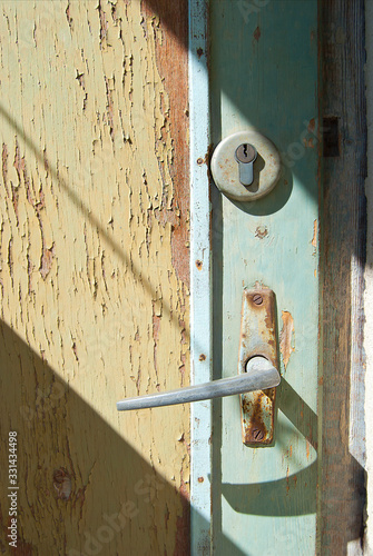 The handle of the old door with cracked paint.