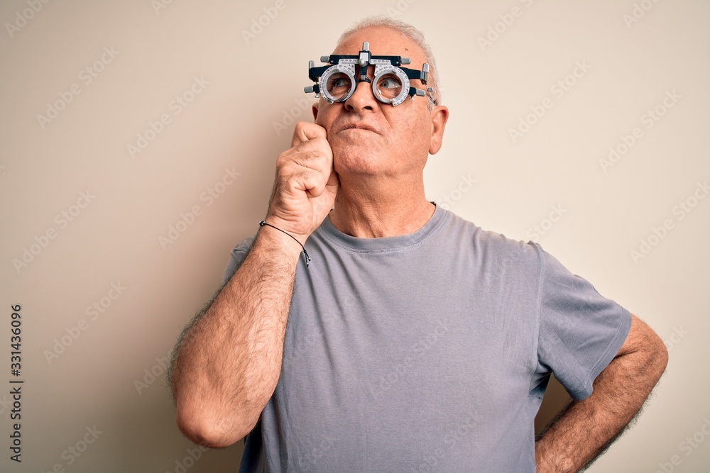 Fototapeta premium Middle age hoary man controlling vision wearing optometry glasses over white background with hand on chin thinking about question, pensive expression. Smiling with thoughtful face. Doubt concept.