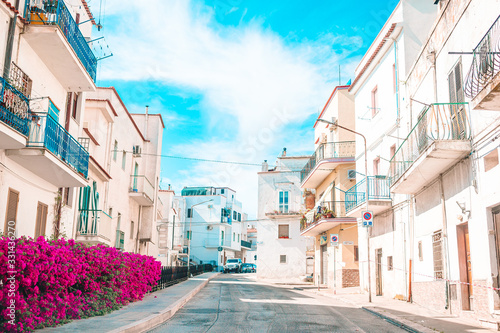 The narrow streets of the island with blue balconies, stairs and flowers.