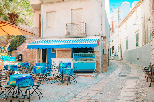 Fototapeta Naklejka Na Ścianę i Meble -  Summer empty outdoor cafe in a tourist place in Italy