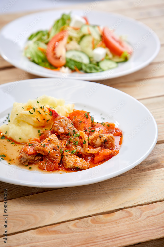 chicken with mashed potatoes and salad on the wooden background