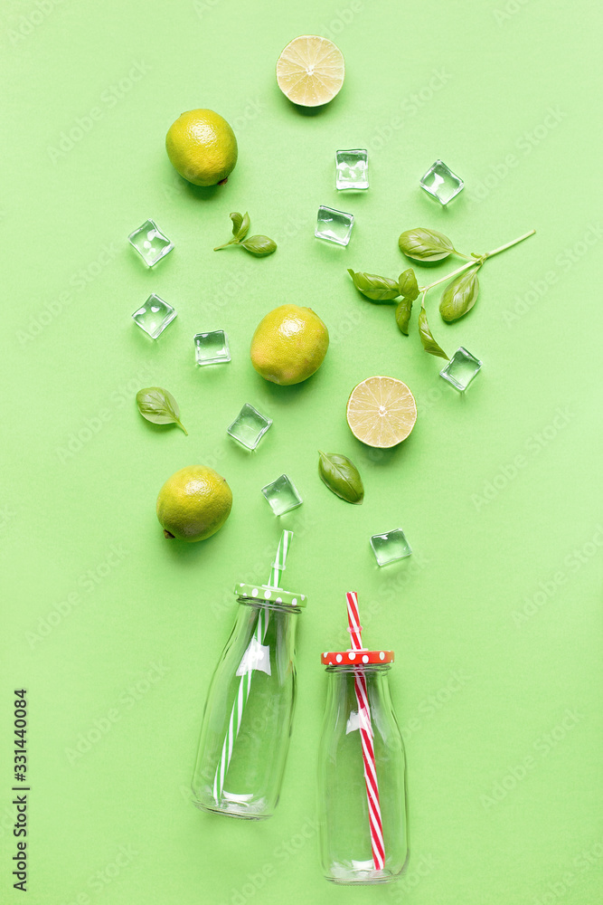 Flat lay with ingredients for summer refreshing drink or smoothie, ice cubes, herbs and glass jars on green background, top view. Strawberry, lime, ice and basil for delicious summer cocktail Flat lay with ingredients for summer refreshing drink or smoothie, ice cubes, herbs and glass jars on green background, top view. Strawberry, lime, ice and basil for delicious summer cocktail