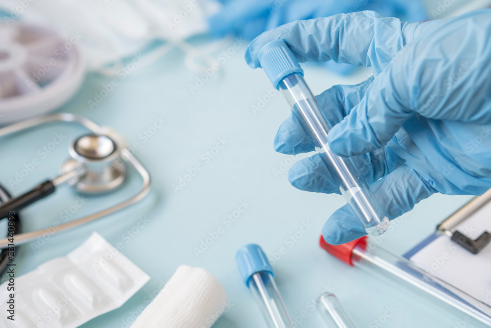 A doctor or nurse holds a test tube to send it to the lab for a blood test. hands of a laboratory assistant with a test tube for taking a blood sample for a virus or flu. Vaccine against the virus A doctor or nurse holds a test tube to send it to the lab for a blood test. hands of a laboratory assistant with a test tube for taking a blood sample for a virus or flu. Vaccine against the virus