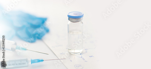 Banner with medicine bottle, blue rubber gloves, syringes and paper with handwritten chemical formulas on light background. Coronavirus vaccine development. 2019-nCoV liquid drug, antidote. Copy space