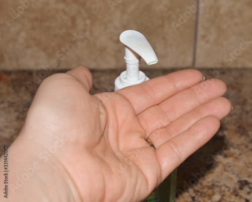 Wallpaper Mural Close up image of an adult female protecting herself from covid 19 by using hand sanitizer  Torontodigital.ca