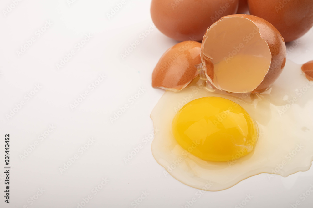 Broken chicken egg and scattered eggs on a white background. Close up. Broken chicken egg and scattered eggs on a white background. Close up.