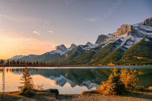 Fototapeta Naklejka Na Ścianę i Meble -  Sunrise on Mount Rundle with blue sky reflection on Rundle Forebay reservoir in autumn at Canmore