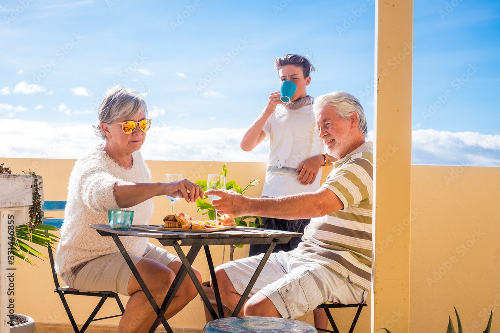 grandfathers adult mature and teenager nephew enjoy outdoor in the terrace some leisure with food and drinks. ocean and city view, vacation sunny day nice weather concept and background. happy people grandfathers adult mature and teenager nephew enjoy outdoor in the terrace some leisure with food and drinks. ocean and city view, vacation sunny day nice weather concept and background. happy people