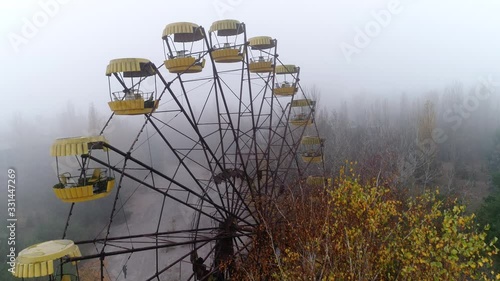 Video from a drone in an abandoned city of Pripyat in the Chernobyl exclusion zone. Ferris wheel in the fog. Amusement park