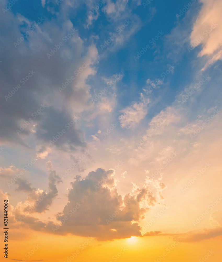 Sky blue and orange light of the sun through the clouds in the sky