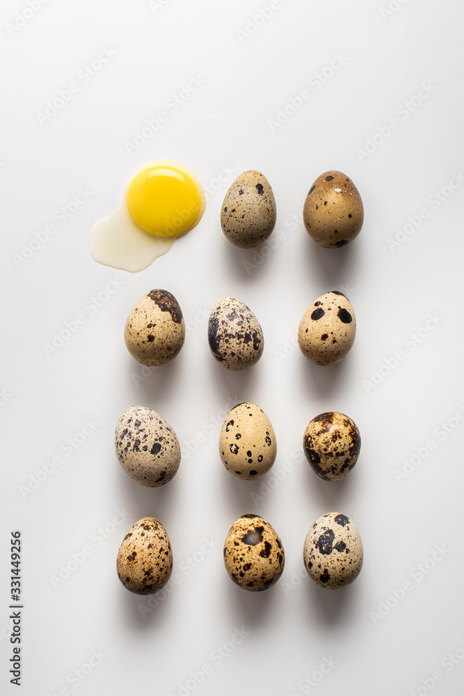 Several quail eggs lie on a light background. Broken egg. Pattern. Easter background