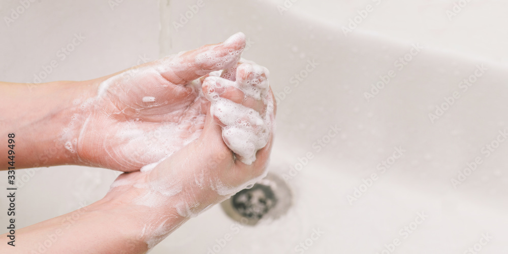 Hand washing with soap. The girl uses soap and washes her hands under a water tap. Hygiene and health protection against viruses and bacteria. Copy space. Hand washing with soap. The girl uses soap and washes her hands under a water tap. Hygiene and health protection against viruses and bacteria. Copy space.