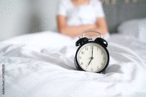 Woman sleep on the bed turns off the alarm clock wake up at the morning, Selective focus..
