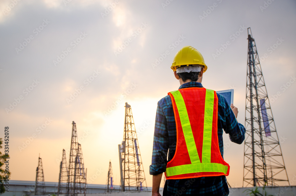 Construction engineers are using tablets to inspect construction projects on the background of the construction site.