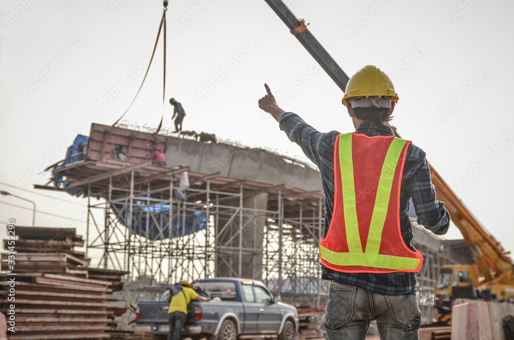 Construction engineer pointing the hand with the background of the construction site Construction engineer pointing the hand with the background of the construction site
