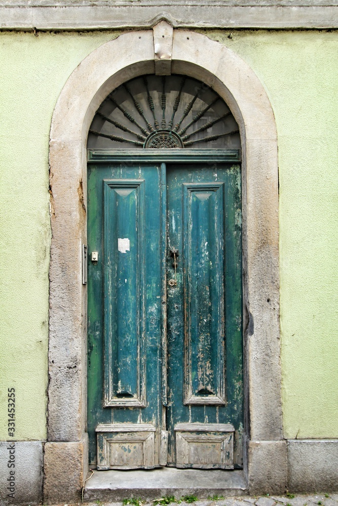 Old and colorful green wooden door with iron details