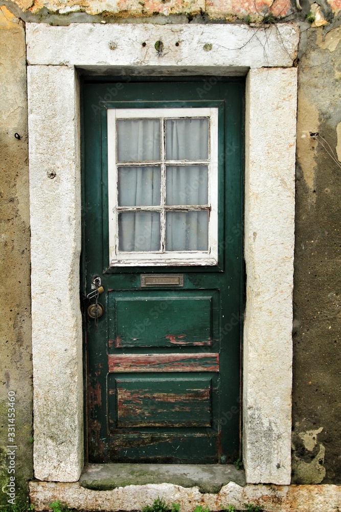 Old and colorful green wooden door with iron details