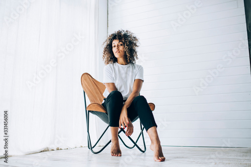 Young female sitting in chair in fashion pose