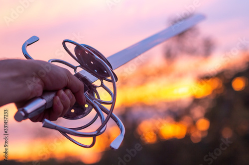 Hand holding large rapier sword