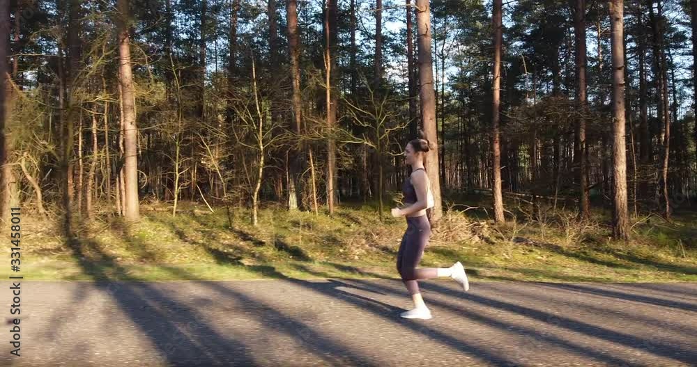 Young woman doing her daily fitness workout routine, running on a track Young woman doing her daily fitness workout routine, running on a track