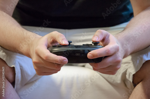 Close up on male hands holding a joystick to video game play