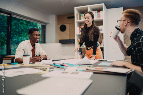 Young colleagues speaking with each other at table