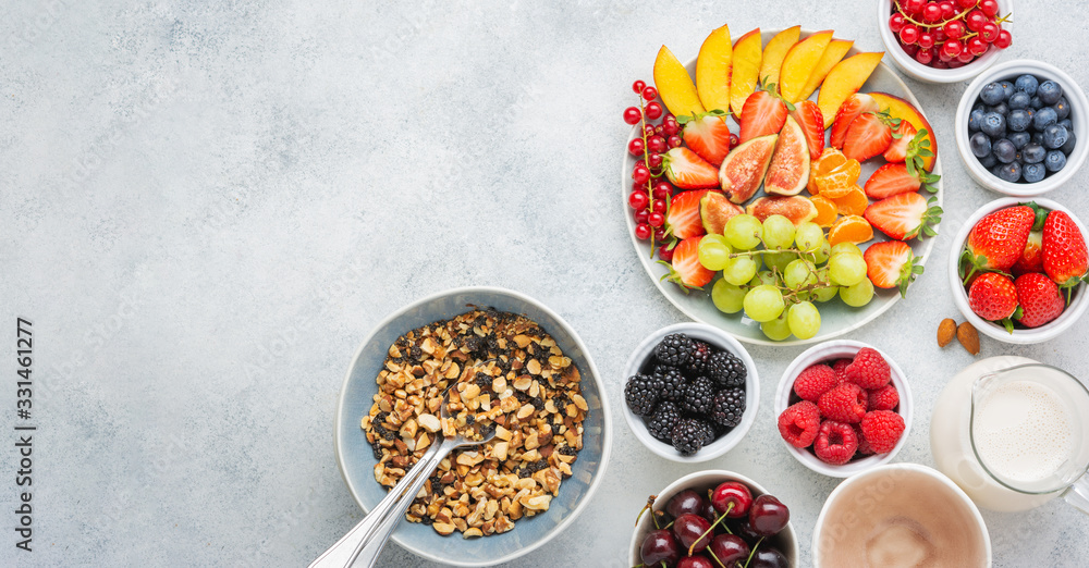 Raw vegan nut paleo style granola or muesli. Fruit berries platter, strawberries blueberries raspberries peach figs red currant, overhead view, banner, copy space for text, selective focus Raw vegan nut paleo style granola or muesli. Fruit berries platter, strawberries blueberries raspberries peach figs red currant, overhead view, banner, copy space for text, selective focus