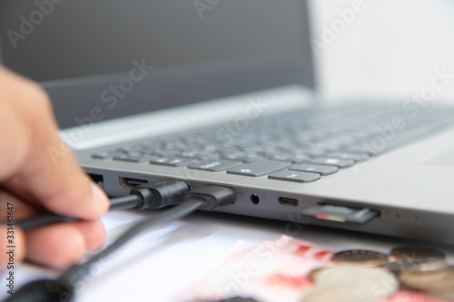 USB in hand on banknote and memory card is plugged into computer