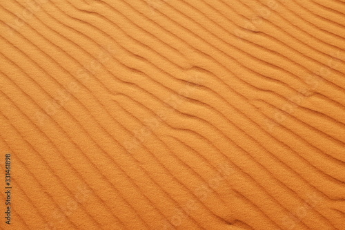 Bright orange desert sand ripples for hot summer background.