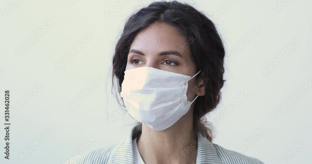 Young woman wearing medical mask looking away at camera. Sick infected adult lady having coronavirus disease covid-19 prevents infection spreading, protects from flu or pollution. Close up portrait Young woman wearing medical mask looking away at camera. Sick infected adult lady having coronavirus disease covid-19 prevents infection spreading, protects from flu or pollution. Close up portrait