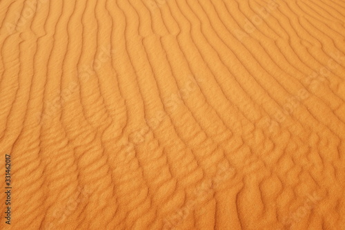 Bright saturated orange color desert sand wave patterns for warm summer background.