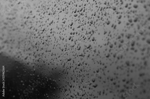 Drops of water on a car glass. Black tinted car window with raindrops. Texture for design.