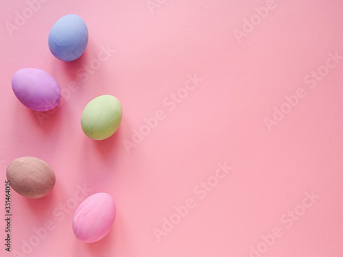 Flat lay composition of Happy Easter holiday concept. Colorful pastel egg on pink background. Copyspace, top view.