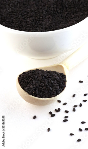 black seeds with a wooden spoon