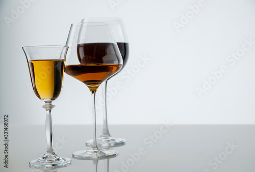 Three glasses of wine of different colors on a white background