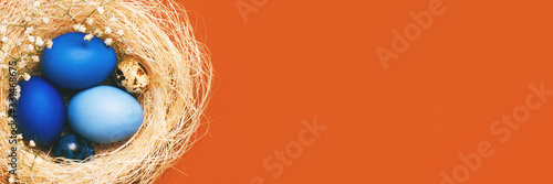 Banner with Easter eggs in blue colors in a nest. Copy space. The concept of stylish decoration for Easter, greeting cards, etc.