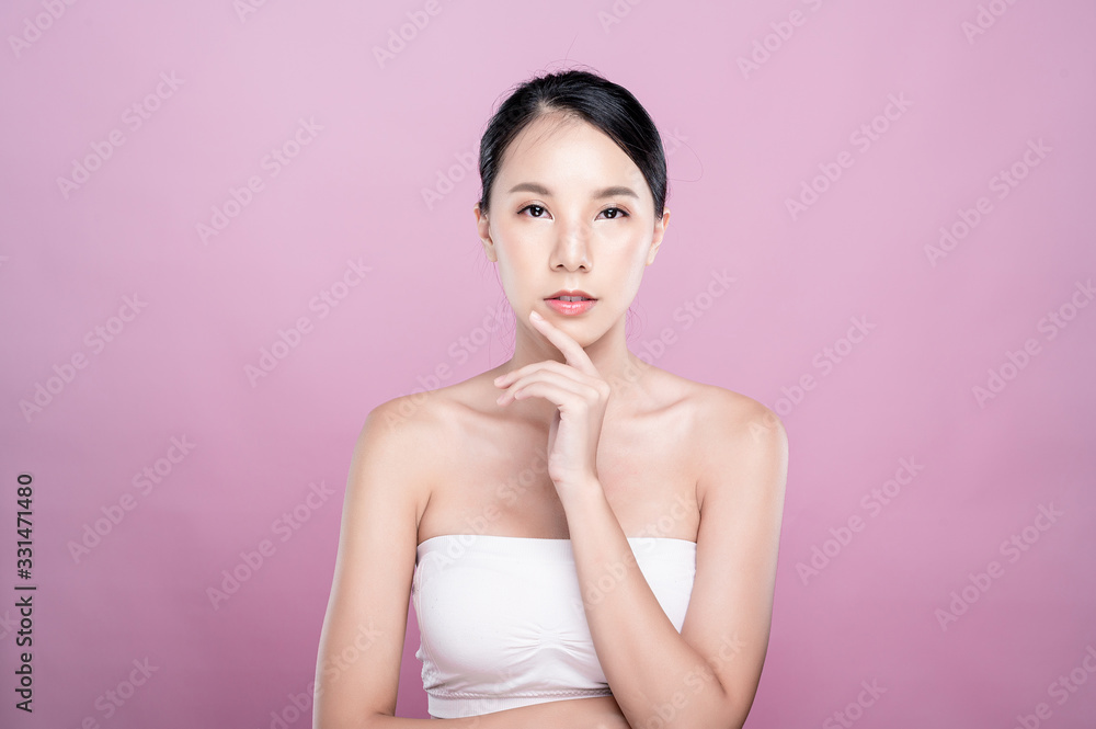 Asian woman poses for healthy skin beauty in pink seamless background. Cosmetic, skincare, surgery concept with copy space. Her skin and face are healthy, beautiful, fresh and youthful. Asian woman poses for healthy skin beauty in pink seamless background. Cosmetic, skincare, surgery concept with copy space. Her skin and face are healthy, beautiful, fresh and youthful.
