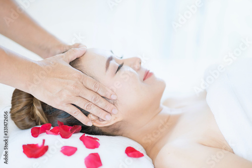 Hand on head. Facial Massage, Spa Massage, Relaxing facial massage at spa salon. Happy young beautiful woman enjoying head massage at the spa beauty clinic.