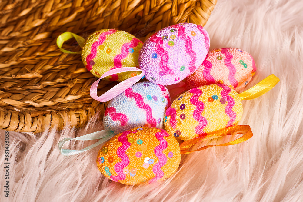 Big wicker basket for colorful shiny easter eggs on textile background. Hunt handmade easter egg. Copy space for text