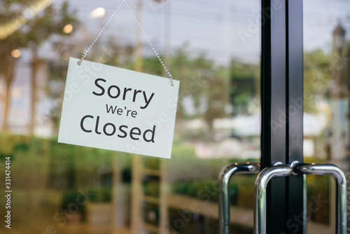 sorry we are closed sign hanging outside a restaurant, store, office or other photo