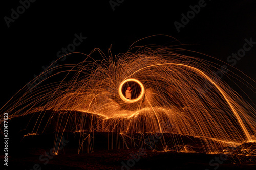 Lighting from spinning steel wool on stone near the sea of Steel Wool Photography.