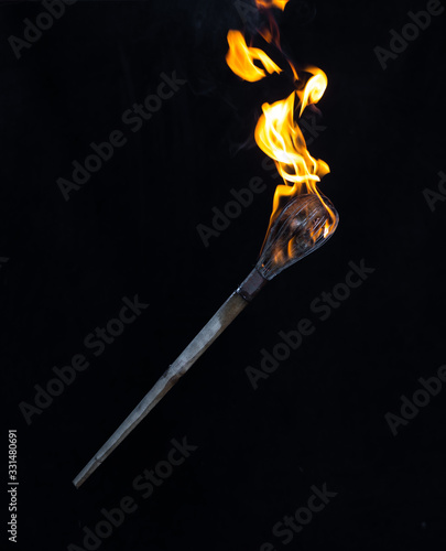wooden burning torch on a black background photo