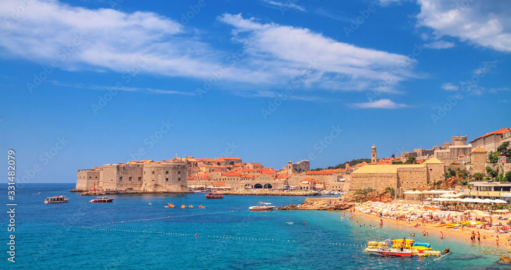 Coastal summer landscape - view of the city beach and the Old Town of Dubrovnik on the Adriatic coast of Croatia