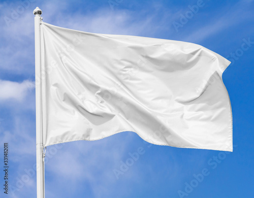 Obraz na płótnie White flag waving in the wind on flagpole against the sky with clouds on sunny day, closeup w salonie
