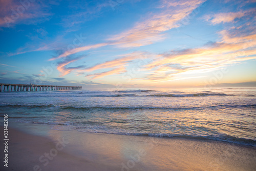 panama city beach florida ocean at shoreline with beautiul sunset clouds and pier into the water