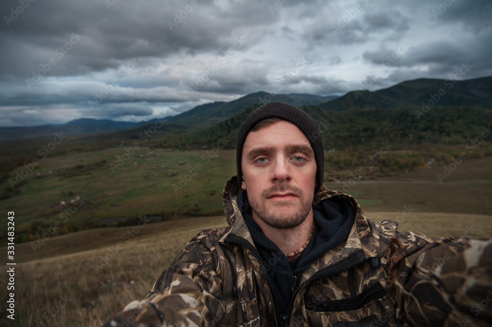 Caucasian man in the mountain making selfie on background nature landscape